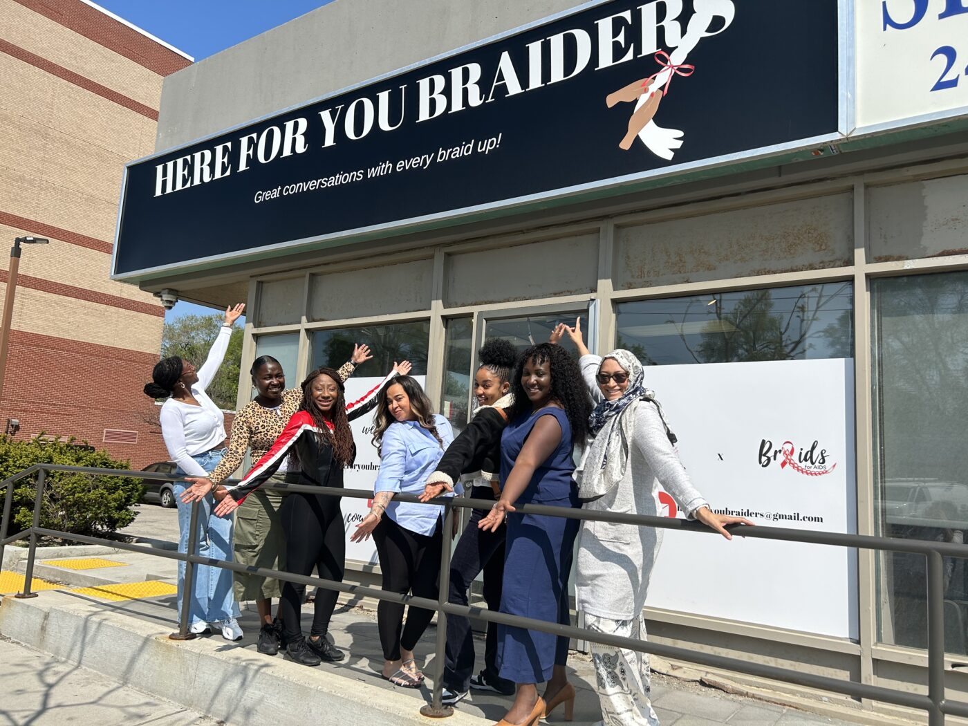 The BrAIDS for AIDS team stand in front of their first salon location in Keelesdale-Eglinton West.