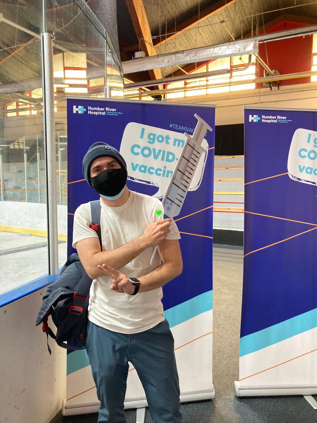 A person in a mask stands in front of a sign that says "I got my COVID vaccine." Sebastian Tansil/The Green Line.