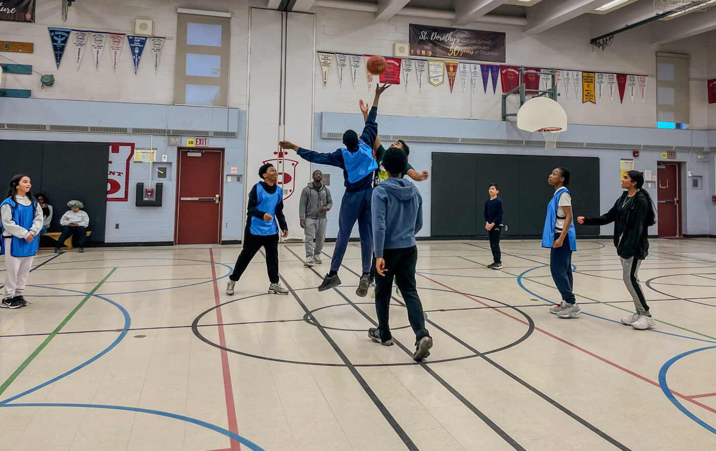 Underserved youth in STEM athletics program play basketball.