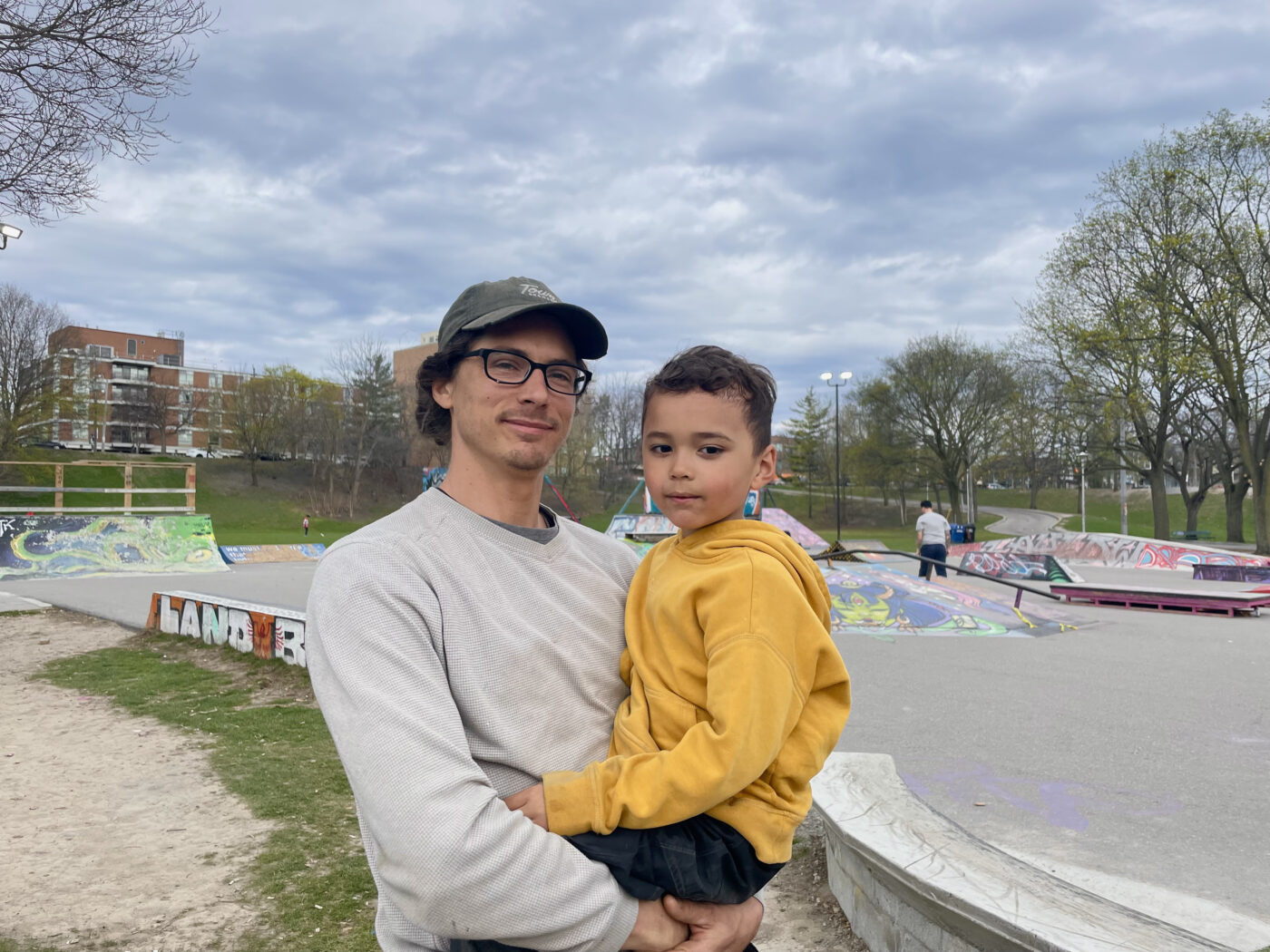 Nicky Young, one of the organizers of Pits DIY, stands with his son Raphael Young by the skatepark at Christie Pits Park.