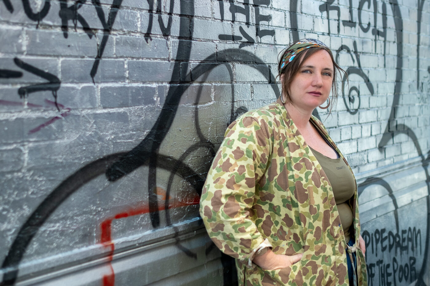 MEGAN KINCH LEANING ON A WALL OF GRAFFITI. 📸: PASQUALINE LE BRAS MEGAN KINCH LEANING ON A WALL OF GRAFFITI. 📸: PASQUALINE LE BRAS