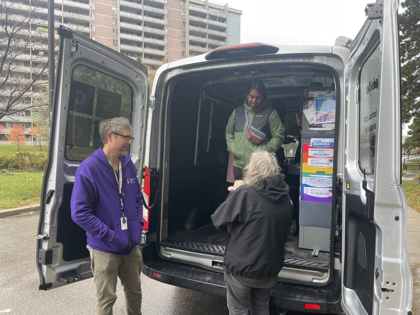 Mobile health unit team stands with resident in Kennedy Park.
