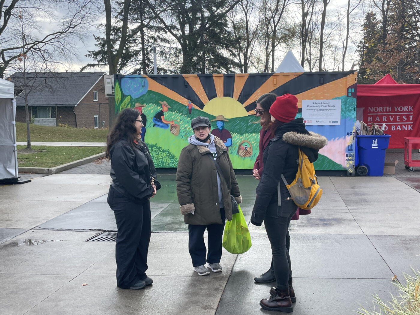 Chashma Akram talks to Jamestown resident outside the food bank.