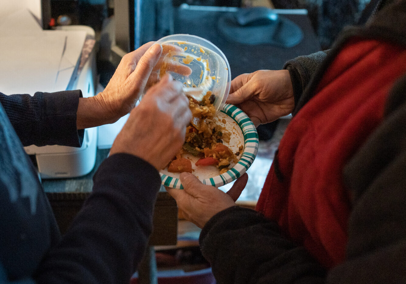 Goldie Wallensky shares dinner with her companion Cad. Their meal consits of leftovers from a community dinner program earlier in the week in North York, Canada, on January 15, 2025. Goldie a vegitarian says "it can be hard to find food for our diets from food banks or community meal programs."