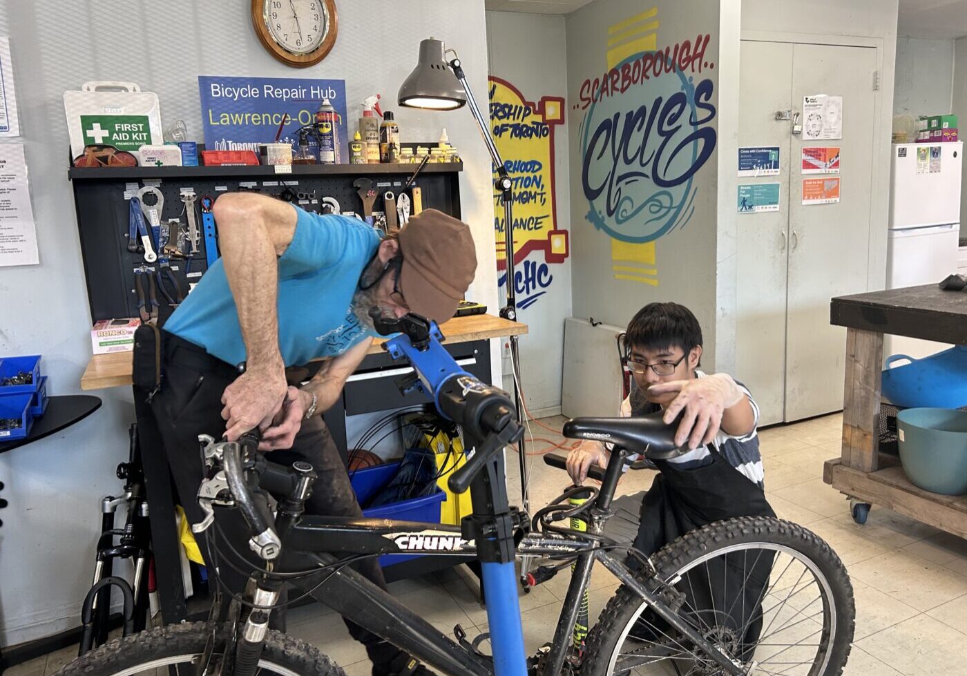 Scarborough Cycles volunteers repair a bike in the Lawrence-Orton bike hub.