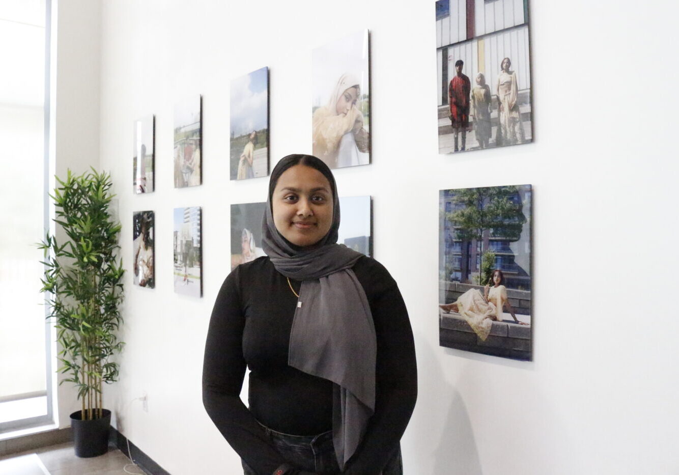 Humaira Rahman stands in front of multiple photos on a wall