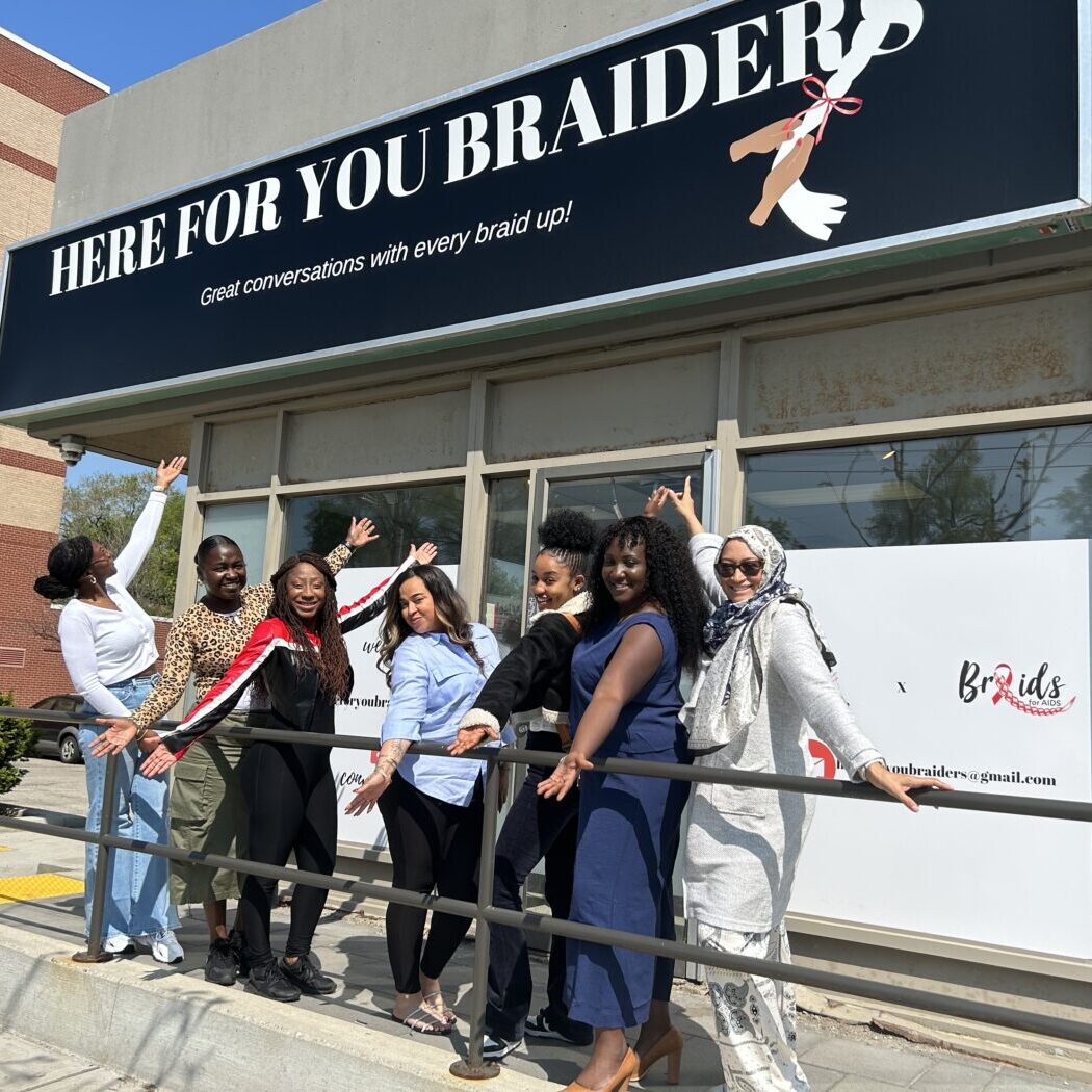 The BrAIDS for AIDS team stand in front of their first salon location in Keelesdale-Eglinton West.