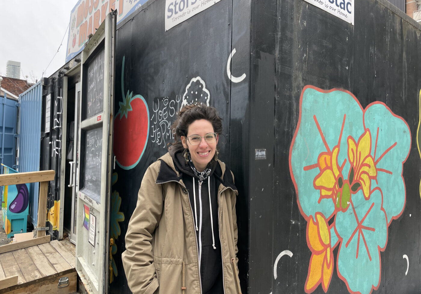 Ella Lightstone stands in front of pay-what-you-can market in Moss Park.