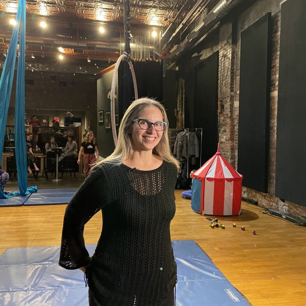 Maria Karam, Executive Director, Redwood Theatre stands in front of circus equipment.