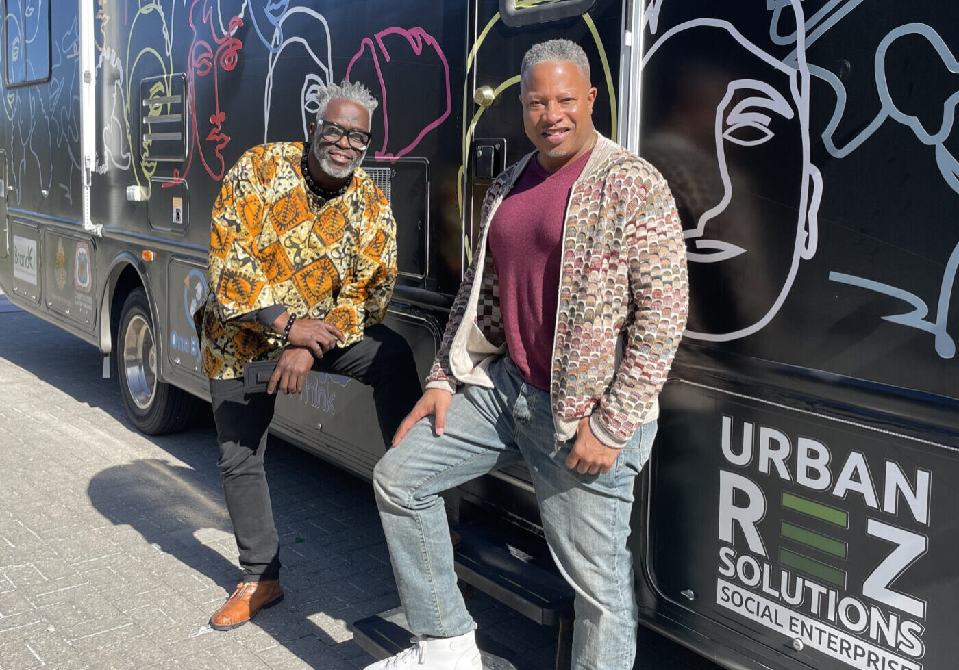 Farley Flex and Roderick Brereton standing by community mobile unit that curbs youth crime.