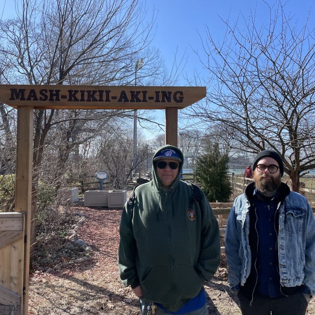 Big Thunder (pictured left) and Karl Cousineau (pictured right) stand in front of the Mashkikiiaki'ng garden in Hillcrest Park