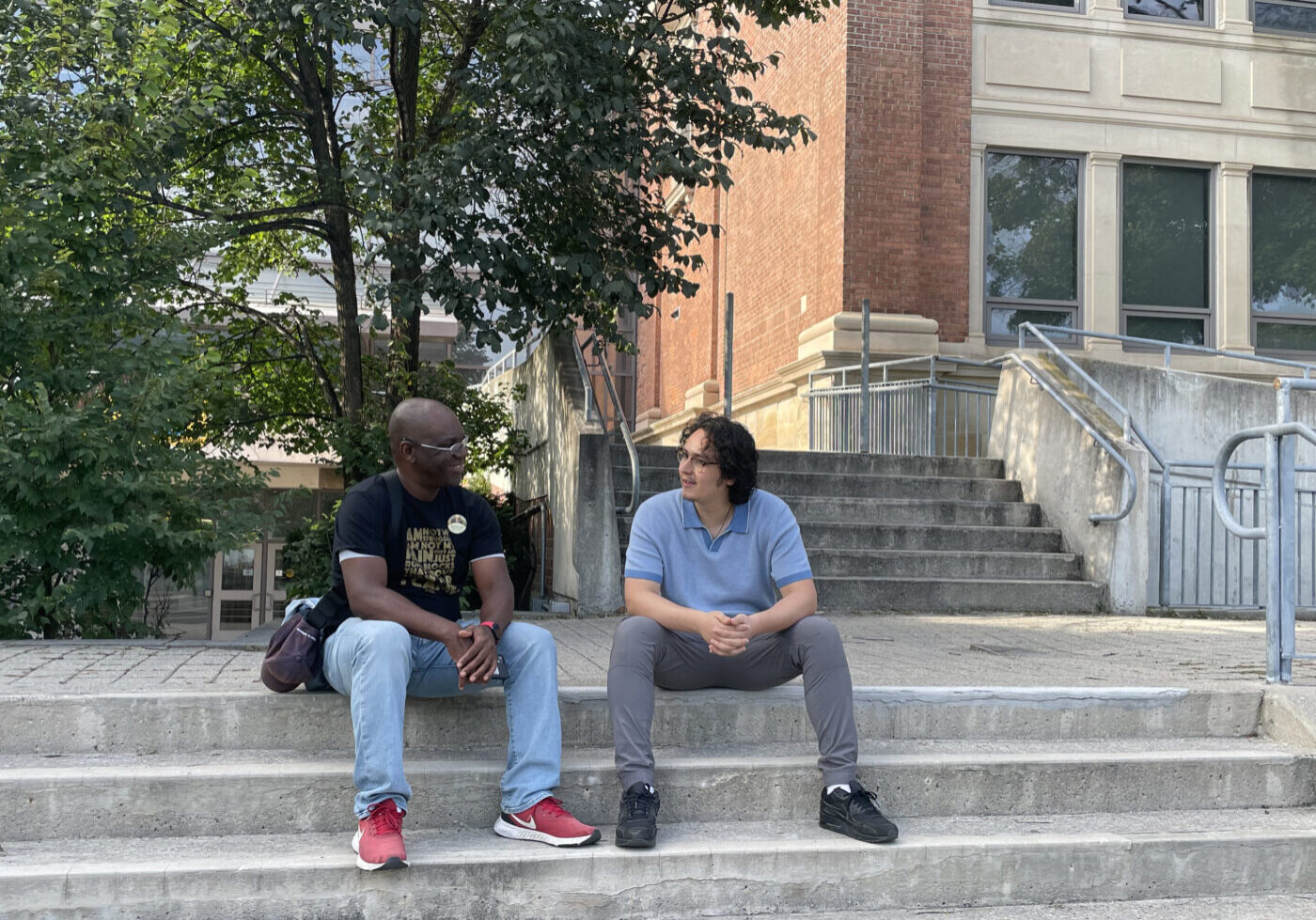 Lanrick Bennett Jr. sits on the staircase with Luke Galati for the Black history walking tour.