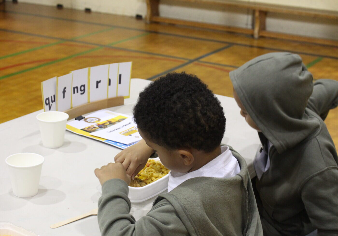 Kids eat food looking at their reading kits.